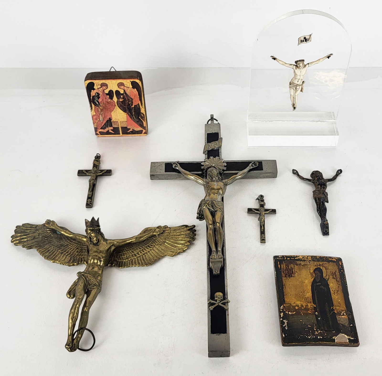 Collection of Religious Icons, 8: A carved bone figure of Christ set in lucite, large silver-tone metal Golgotha crucifix, two small Golgotha crucifixes, a partially gilt metal crucifix, a print of a manuscript illumination mounted on