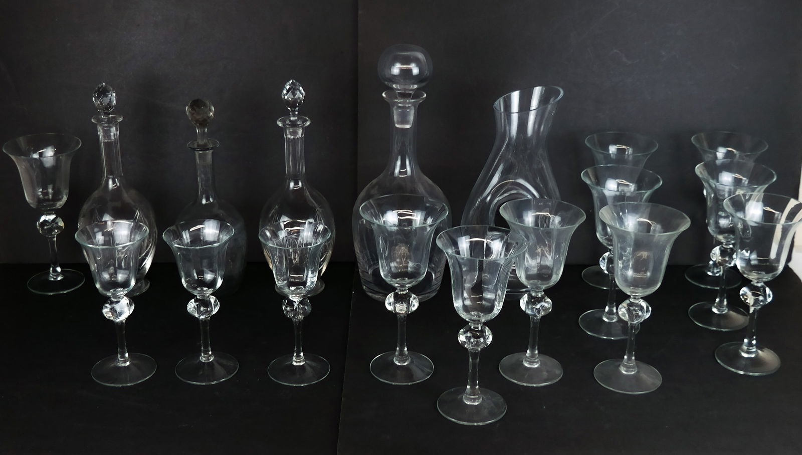Crystal and Art Glass Serveware, 19: 14 art glass goblets with reticulated cups and hand blown stems comprising 11 red wine goblets and three white wine goblets, three etched crystal decanters, including a pair marked "Nancy, France," to