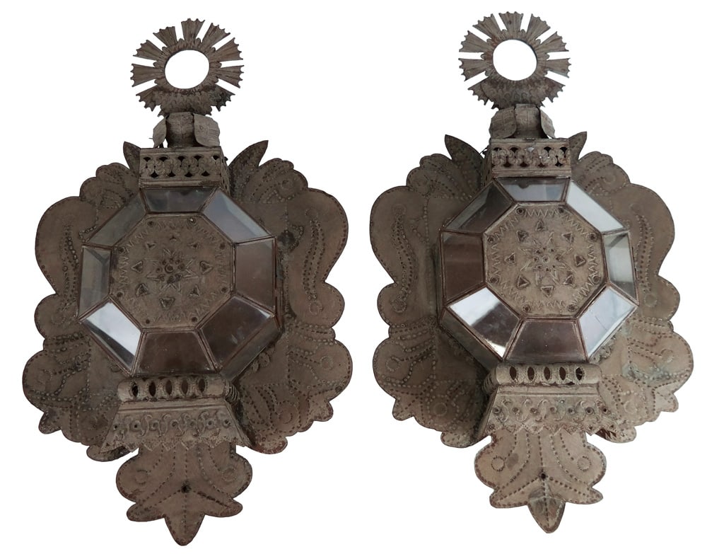 Pair of Cut and Pierced Zinc Sconces: A pair of cut and pierced zinc sconces, Mexican, early 20th century, with a decorative crown over a central octagonal and glass inset case, before a decorative plate. [25" H x 14" W x 3.5" D]. Overall