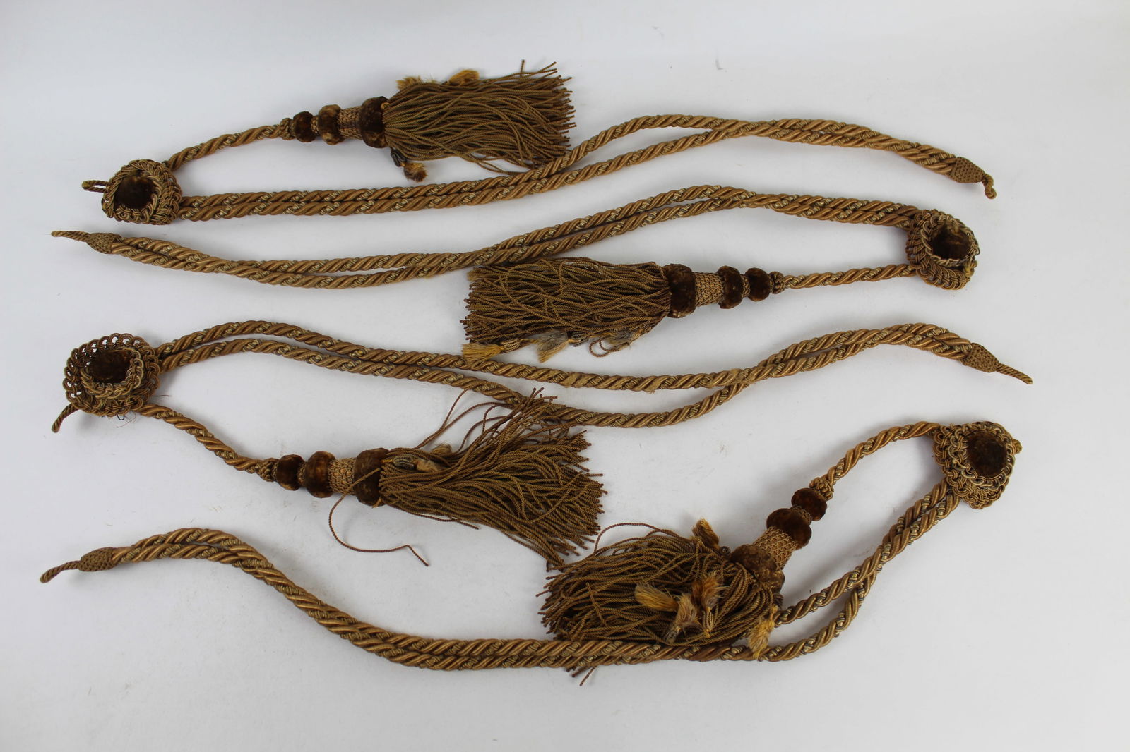 Set of 4 Antique Braided Silk Velvet Tassels: Set of four antique braided silk velvet tassels: the tassels with added yellow silk fringes, on thick golden yellow and red braided and knotted cords, attached to matching rosettes. Provenance: Lucien