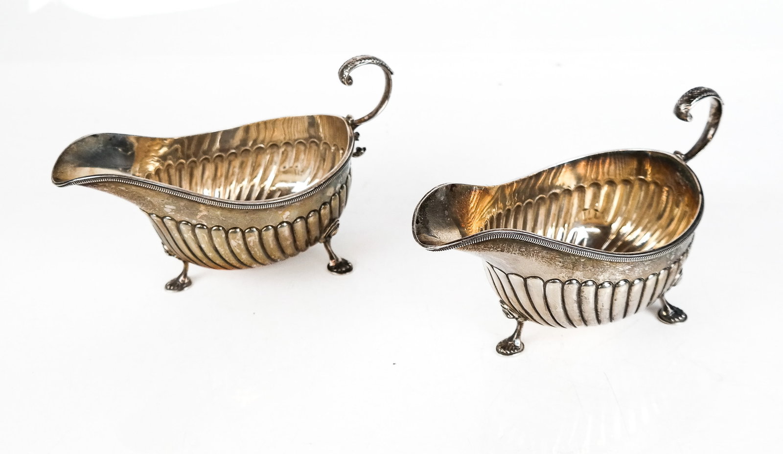 The Alexander Co. Pair Sterling Silver Gravy Boats: The Alexander Co. pair of sterling silver gadrooned and monogrammed gravy boats, total 15 ozt., marks to base. [4" H x 7.75" W x 3.25" D]. Overall condition is good, minor dings, tarnished. From the E