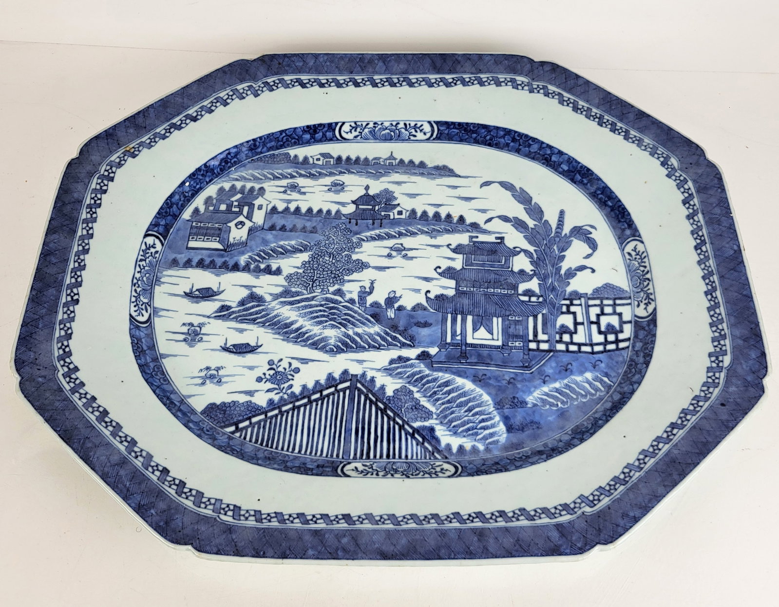Chinese Blue & White Porcelain Platter: Ovoid octagonal shape porcelain platter with scenic center design, in Canton style. [20" x 17"]. From the Estate of Laura Leonard Ault.
