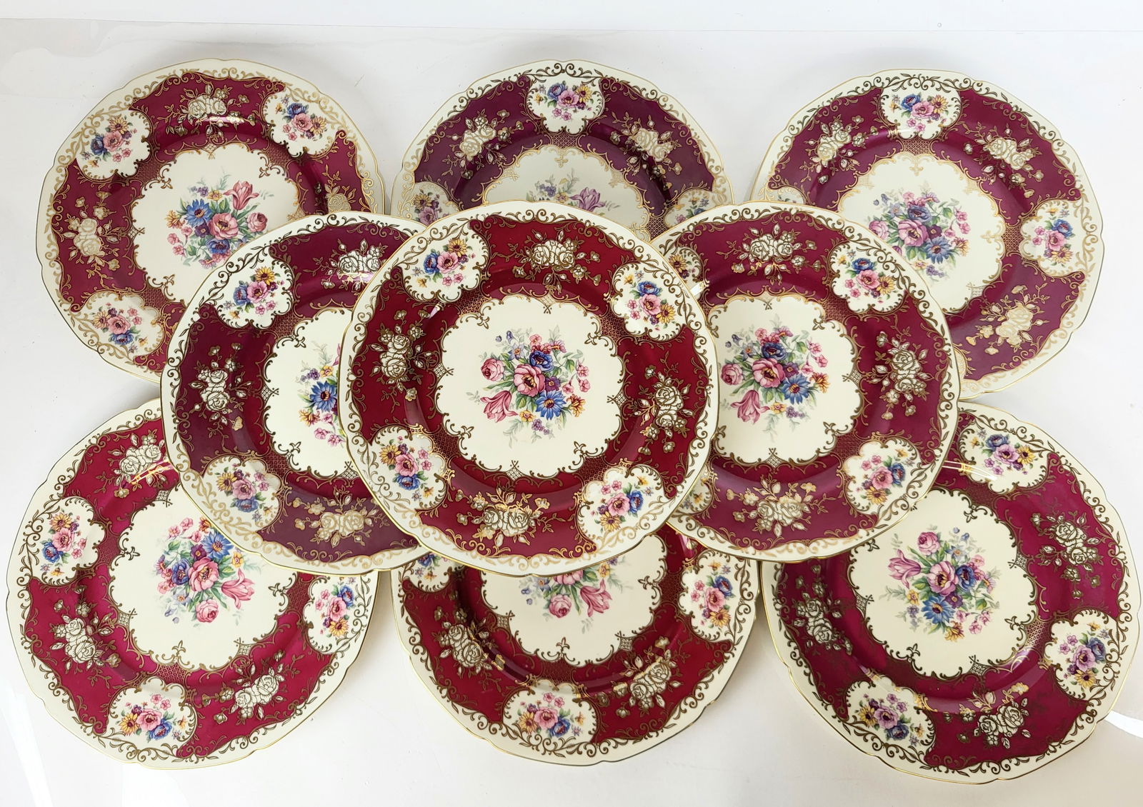 Set of 9 Royal Czech Place Plates: Set of nine Royal Czech place plates, epiag, with floral and gilt around pink ground. [10.75" Diameter].