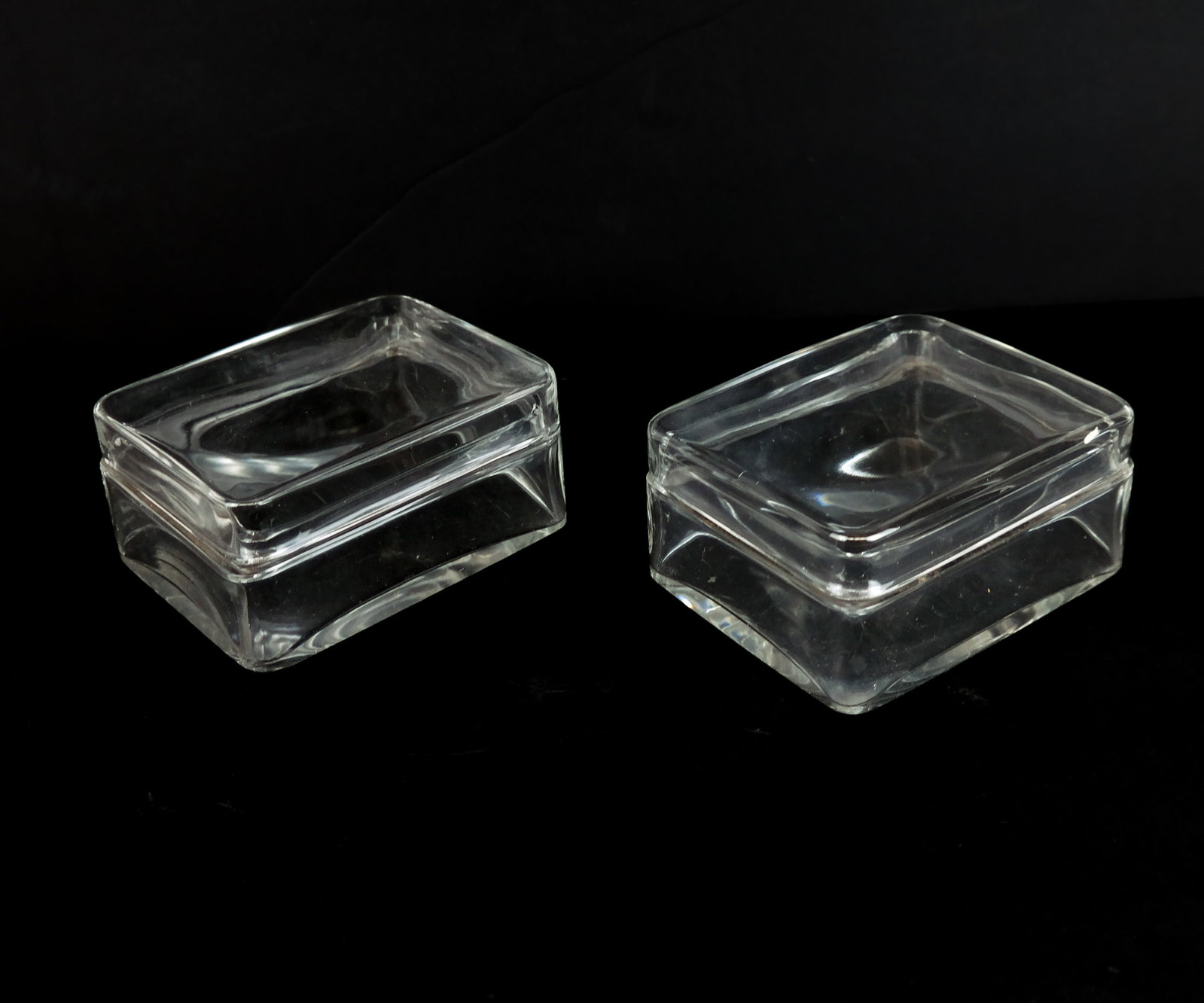 Baccarat Pair of Crystal Boxes: Baccarat pair of crystal boxes, marks to base. [2.5" H x 5" W x 4" D]. Overall condition is good, excluding scratches to base. From the Estate of Laura Leonard Ault
