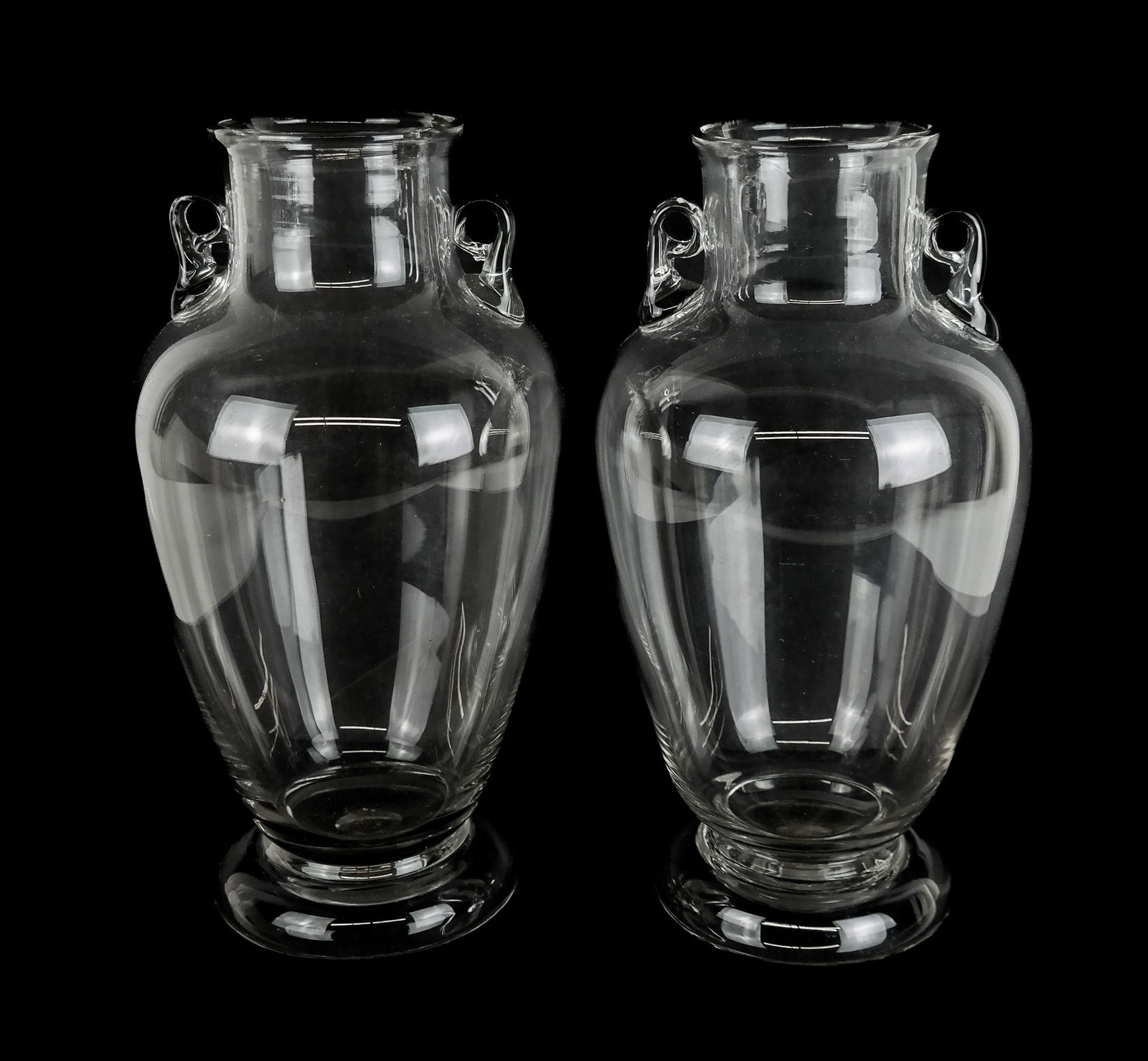 Pair Amphora Form Art Glass Vases: Pair amphora form hand-blown art glass vases, 20th century, possibly Murano, with hand-attached handles and a foot. [11.25" H x 6" Diameter]. Overall condition is good. From the estate of Laura Leonar