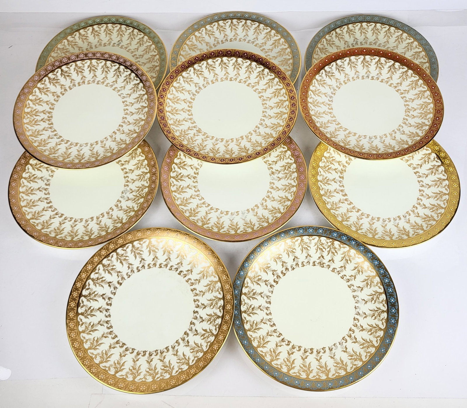 Royal Worcester Gilt and Cream Luncheon Plates, 11: Royal Worcester 11 floral and gilt decorated "jeweled" border luncheon plates, England, 1888, Rd No. 68548, each with cream ground and gilt "jeweled" border suspending foliate tendrils, the borders in