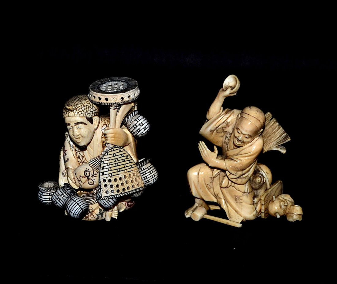 Two Carved Ivory Okimono Figures, Merchants: Comprises a seated smiling basket merchant holding a mask [3 5/8" H] and a junk dealer with pots, pans, and raccoon companion [4 1/8"]