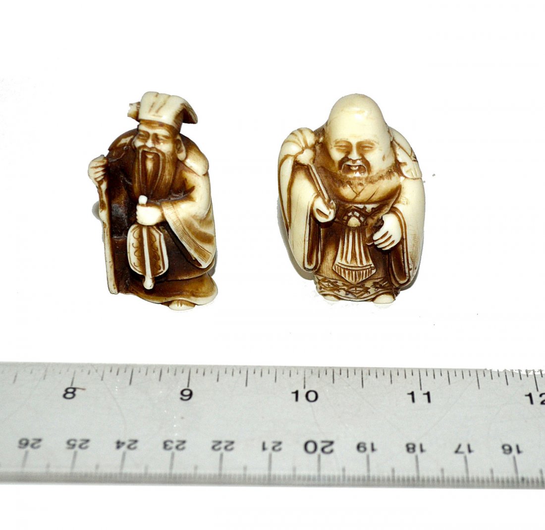 Two Ivory Netsuke Figures: Comprises: 1.) Bald figure with scepter [2" H] 2.) Scholar with musical instrument and staff [2 1/8" H].