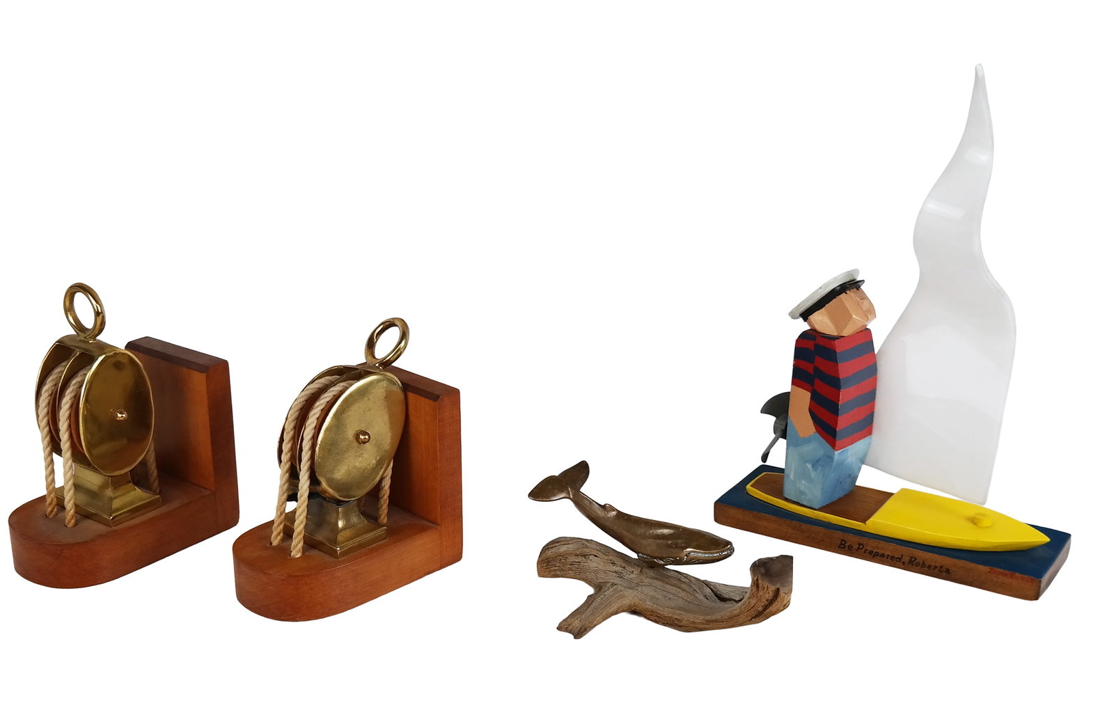 Four Nautical Items: Four nautical items, including a pair of anchor-rope bookends, a sculpture of a whale on driftwood, and a sculpture of a sailor on a ship by Don Russell titled "Be Prepared, Roberta". [Largest: 14" H 