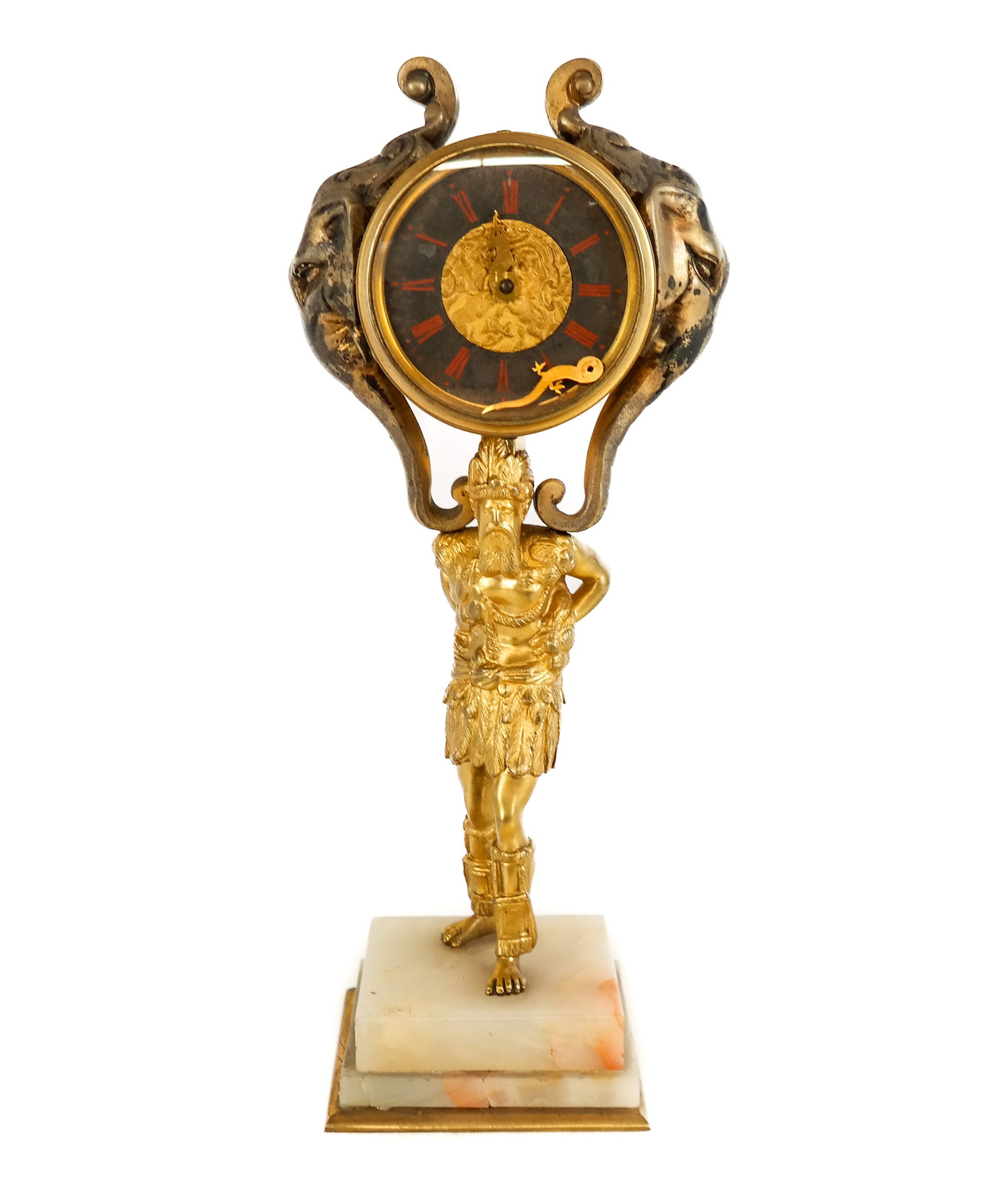 Figural Gilt Metal Clock on Stand: Figural gilt metal clock on stand, 29th century, with a decorated face, elephant form masks to each sides, and a figural stand on white onyx base. [10.5" H x 5" W x 3" D]. Condition is poor with one c