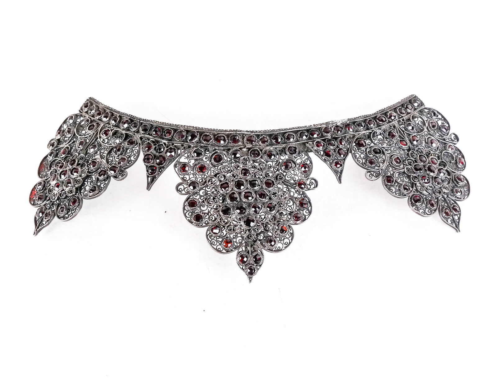 Antique Silver and Garnet Headpiece: Antique silver and rose-cut garnet filigree headpiece, late 19th century, Indo-Persian inspired, the arched band with hooks for ribbon attachment. [Overall: 4" H x 7.5" W x 2.5" D]. Overall condition 