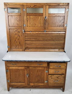 Sellers Oak Hoosier Cabinet: Sellers oak Hoosier cabinet, American, early 20th century, with a two door cabinet to upper over an accordion door compartment and tall cabinet, with a pull out enamel work top over drawers and a two