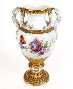 Meissen Porcelain Urn: Meissen porcelain urn, German 1825-1924, with gilt details at lip, body, and base, and snake form handles with hand-painted floral decoration to each side, with the first quality Meissen mark to base.