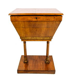 French Empire Sewing Table: French Empire sewing table, 19th century, with a rosewood veneer, gilt wood details, and an affixed base, compartments to interior. [28.5" H x 18" W x 12.5"D]. . Condition is good with minor losses to