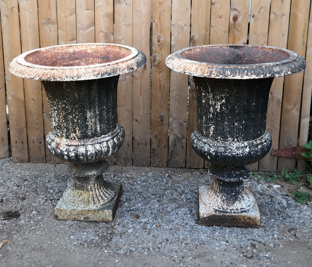 Pair Cast Iron Urn form Jardinieres: Pair of cast iron urn form jardinieres, 19th century, with a decorated upper on a square base. [19" H x 15" Diameter]. Condition is good with rust and wear to paint.