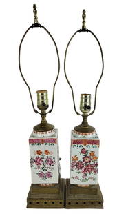 Pair of Chinese Export Famille Rose Table Lamps: Pair of Chinese Export famille rose table porcelain lamps, the squared bodies with round tops and bases, resting on a stepped gilt metal base. [16" H to socket x 14" Square]. Overall condition is good