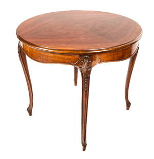 Louis XV Flame Mahogany Center Table: Flame mahogany center table, 20th century, with a quad-matched top over a carved apron and four carved cabriole legs. [29" H x 33.5" Diameter]. Condition is good with minor wear to top and losses to v