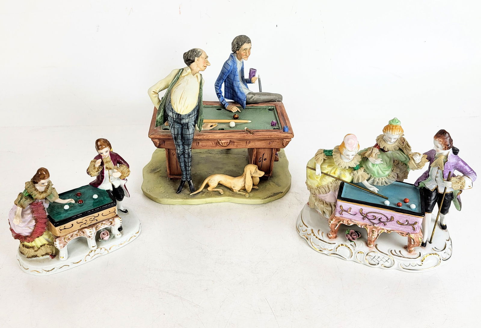 Three Porcelain Figural Groups at Billiards: Three porcelain figural groups at billiards, including Capodimonte "The Pool Hustler" by Cucci, signed to base, and titled to lower, a porcelain group of two players at billiards with lace additions,