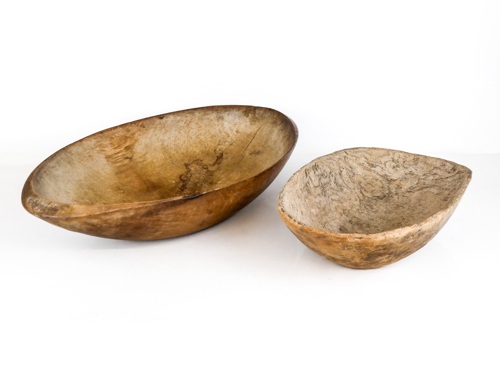 Two African Carved Wood Bowls: Two African carved Troth-manner wooden bowls of very simple rustic oval form. [5" H x 14" W x 25" D; 5" H x 11" W x 17" D]. From the Collection of Susan and Cliff Freeman.