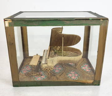 Beadwork Sculpture of a Piano in a Glass Case: Beadwork sculpture of a piano, 20th century, with gilt metal accents, in a glass case, with a lacework decorated bottom. [8" H x 10.25" W x 6.75" D]. Condition is good to fair with wear to case. Estat