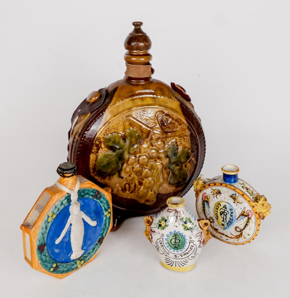 Italian Majolica and Other Flasks, 3: Three flasks, 20th century, comprising a large Czech or Bulgarian flask on feet with impressed grape design, and two Italian majolica flasks. [Largest: 12.5" H x 9.5" W x 4.5" D]. Condition is good wi