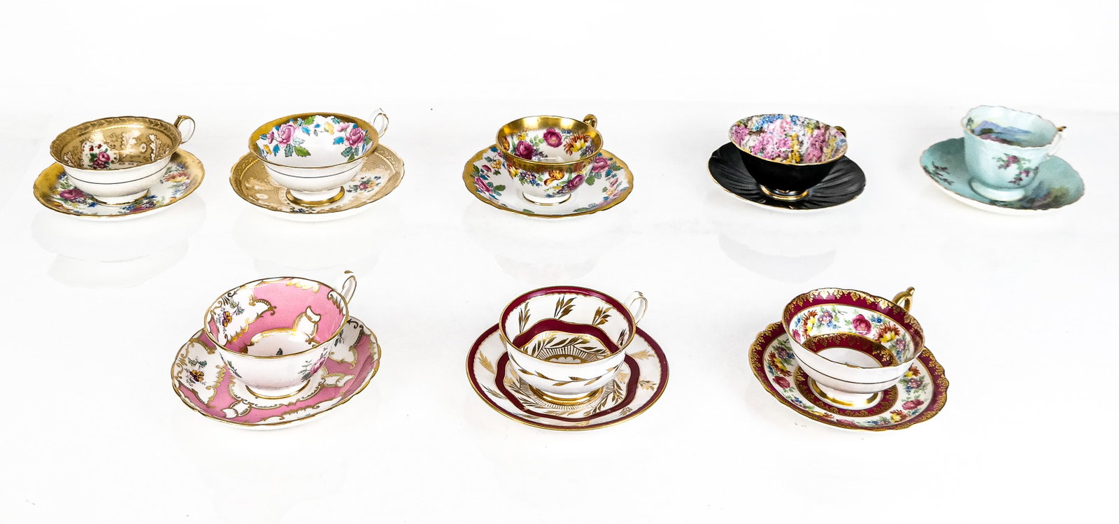8 Teacup and Saucer Sets inclu. Tiffany & Co.: Eight cup and saucer sets comprising a Cauldon Tiffany & Co. floral and gilt decorated teacup and saucer, Paragon floral, red, and gilt decorated teacup and saucer, an Aynsley landscape decorated teac