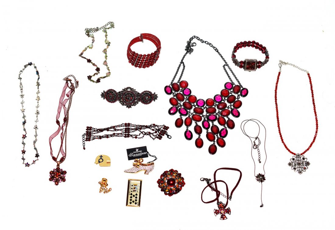 Assorted Red Stone Costume Jewelry: Comprises: seven necklaces, two bracelets, three brooches, two pins, a tie clip, and a watch. Includes: colored glass, garnets, paste stones, and Swarovski crystal. 16 items total.