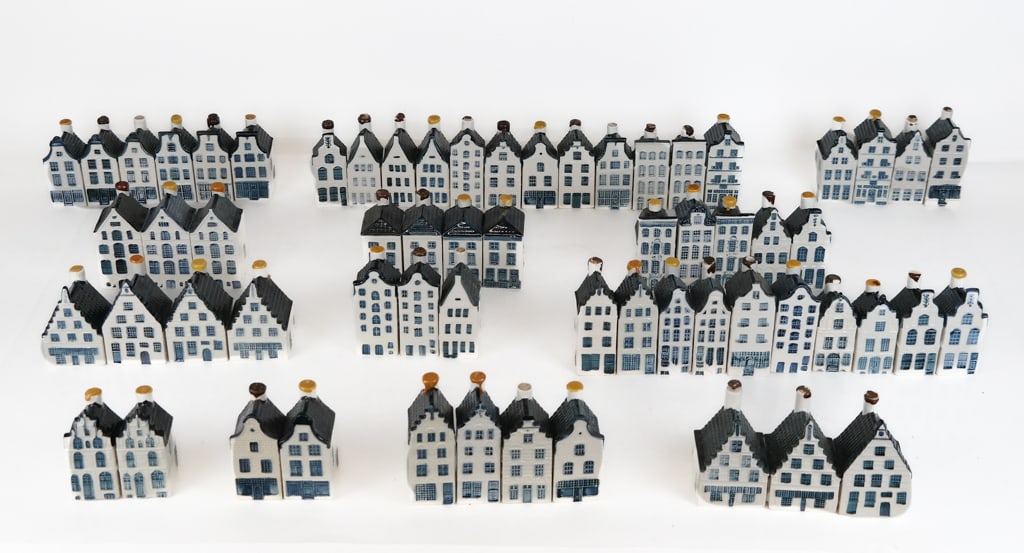 Collection of KLM Delft House Figural Flasks, 60+: Collection of KLM Delft house architectural figural flasks, variously designed including model numbers 21-37, and 46, marks to reverse and bases. [Tallest model 28: 4.5" H x 1.75" Square. Overall cond