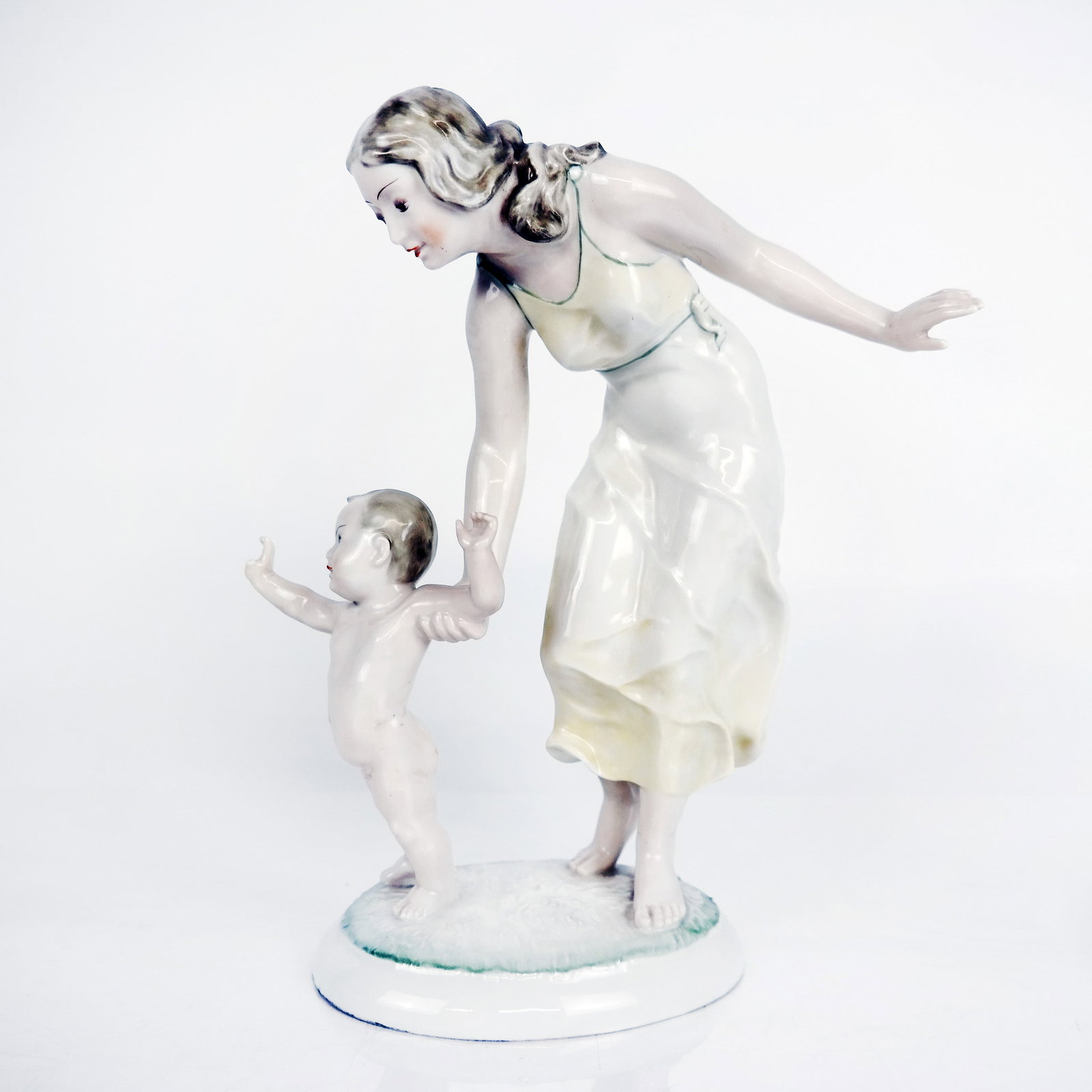 Hutschenreuther Porcelain Figurine: Hutschenreuther porcelain figure modeled as a mother and child, Germany, marks to base. [11.75" H x 9" W x 4.5" D]. Overall condition is good.