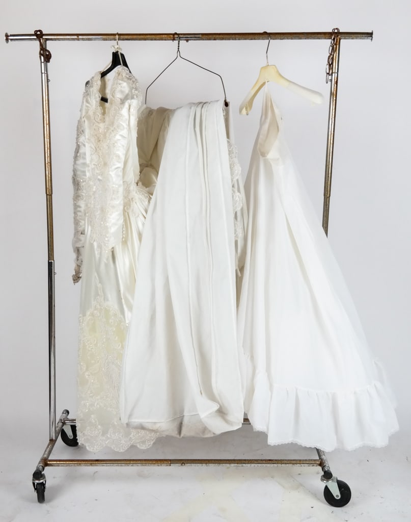 Gloria Vanderbilt Beaded and White Satin Wedding D: Gloria Vanderbilt white satin and beaded wedding dress, 21st century, with lace detailing and long sleeves and a train; crinoline included and with a garment bag from David's Bridal. [Size approximate