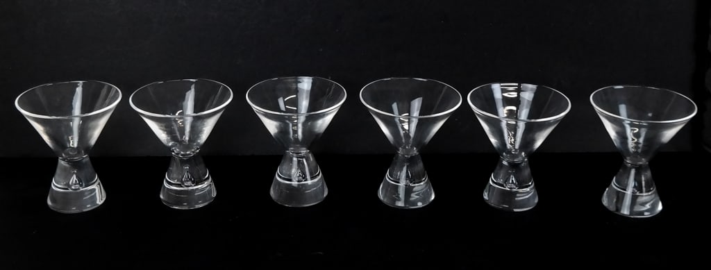 Six Steuben Teardrop Crystal Martini Glasses: Six Steuben cocktail or martini glasses in crystal with a teardrop shape to base, all signed Steuben. [4" H x 3.5" Diameter]. Condition is good with minor scratches to bases.