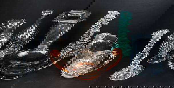 Assorted Glass Wares, 7: Assorted glass serve ware comprising a vase with a curled lip marked Made in France, a glass candlestick, a glass decanter, a glass pitcher, a footed vase with scalloped lip, a stacked glass candlesti