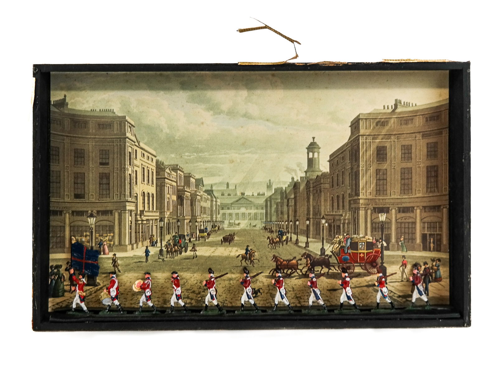 English Soldier Diorama: English soldier diorama, label verso "Regent Street from Piccadilly". [8" H x 13" W x 1.5" D]. Frame as is.