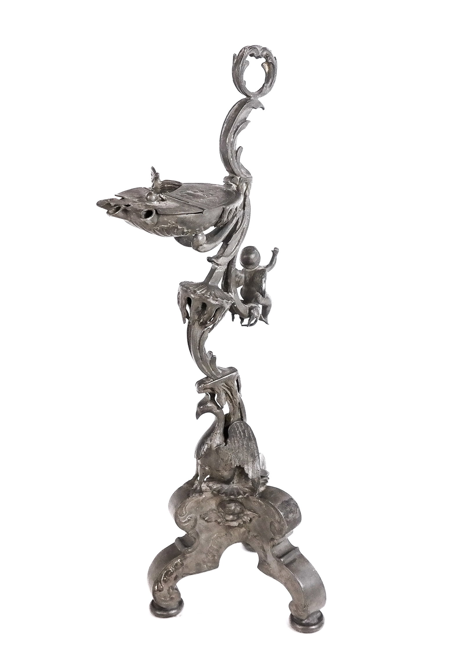 Grand Tour Lead Oil Lamp: Grand Tour lead oil lamp, 19th century, with a bird-decorated oil holder at upper, with a putto decoration to reverse, phoenix to neck, and tripod legs. [14.25" H x 5" W x 5" D]. Condition is good wit