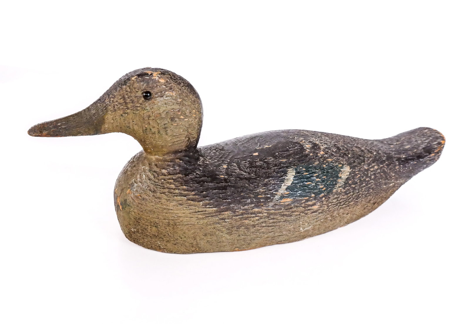 Carved Wood Decoy Duck: Carved wood decoy duck, likely American, with glass eyes and cork and metal element to lower. [6.5" H x 16.5" W x 5.5" D]. Condition is good with scuffing and cracks at lower.