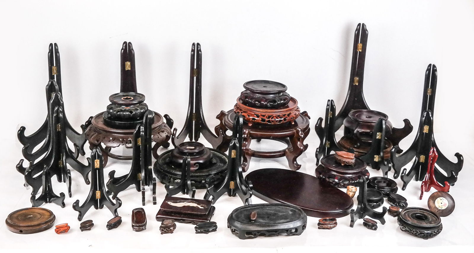 Assorted Chinese Wooden and Other Stands, 53: comprising a pair of round carved wood stands, eleven carved round wooden stands, three dininutive round stands, eleven diminutive irregular snuff bottle stands, two larger irregular stands, a flat ov