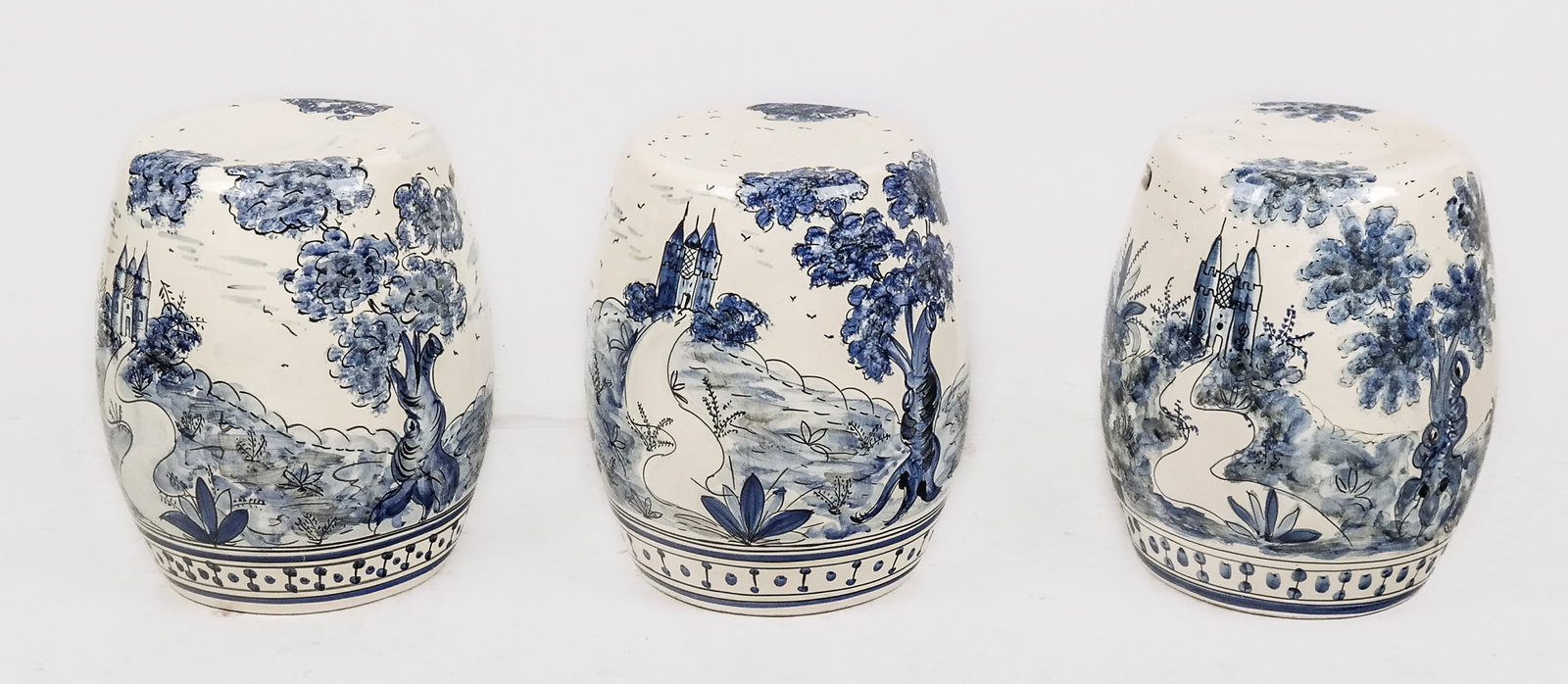 Three Spanish Porcelain Garden Seats: Three Spanish hand-painted porcelain garden seats, 20th/21st century, with hand-decorated blue and white landscape design and border to foot, unmarked. [16" H x 14" Diameter]. Condition is good with m