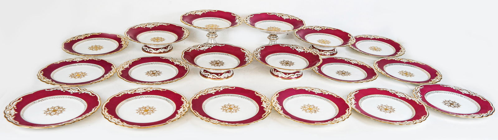 Davenport Porcelain Partial Service, 18: Davenport partial service, late 19th century, with raspberry ground and gilt and pierced decoration comprising four tazzas, two compotes, and twelve dinner plates, all with the 1870-1886 standard Dave