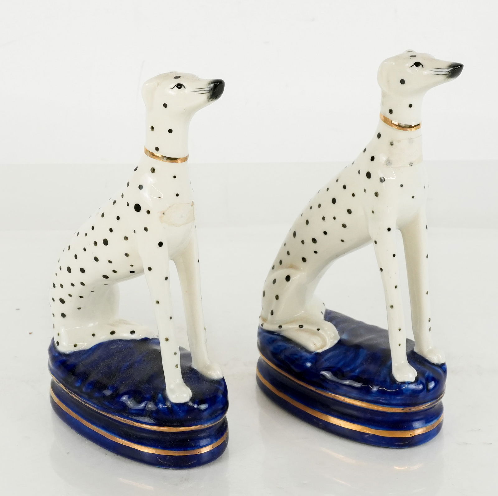 Pair of Fitz and Floyd Porcelain Dalmatians: Pair of Fitz and Floyd porcelain dalmatians, Japanese 20th century, on blue bases, one with Fitz and Floyd label affixed to base. [9" H x 5.25" W x 2" D]. Condition is good.