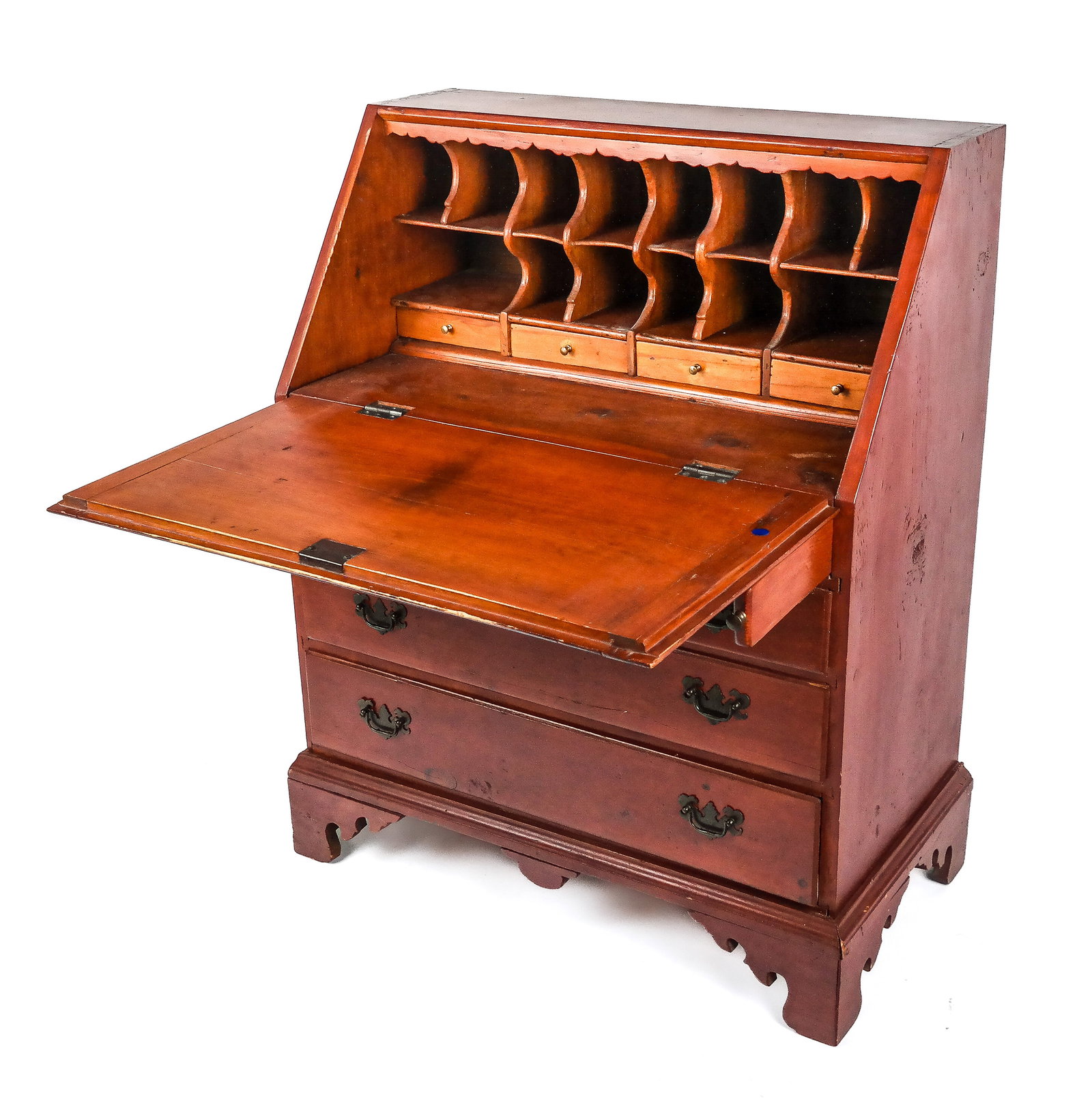 Slant Front Secretary: Drop front secretary, 19th/20th century, with a slant front revealing pigeonholing over four short drawers, with four drawes to lower and a carved skirt, red painting likely later. [43" H x 34" W x 19