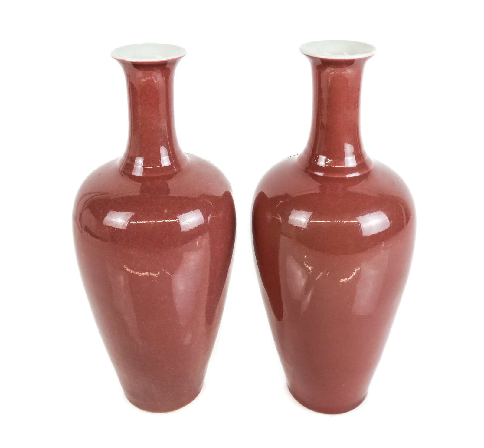 Chinese Pair of Sang de Beouf Baluster Vases: Pair of Chinese sang de beouf oxblood baluster vases, 19th century, one with a blue glazed decoration at base, otherwise unmarked. [12" H x 5" Diameter]. Condition is good.
