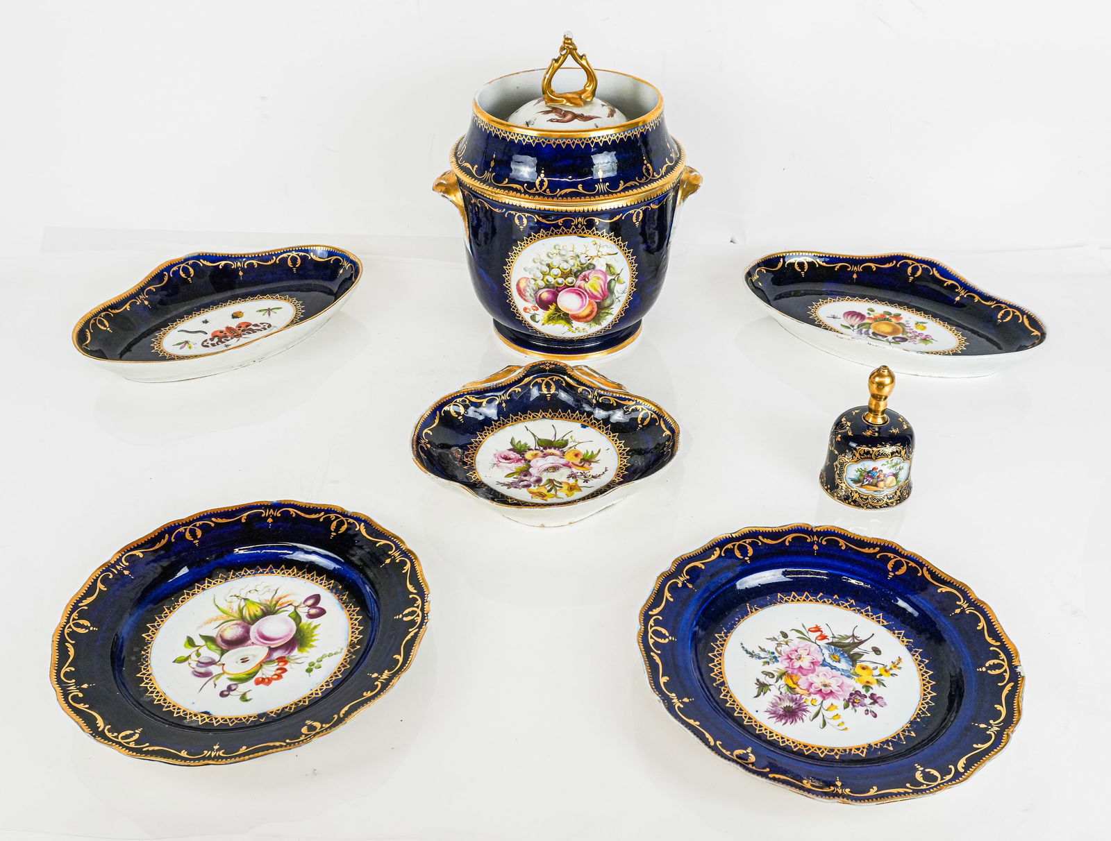 Cobalt Blue Hand-Painted and Gilt Porcelain, 7: Seven porcelain articles, 19th century, with cobalt blue and hand-painted and gilt decoration comprising two dinner plates, two vegetable dishes, a shell dish, and a covered fruit cooler, accompanied