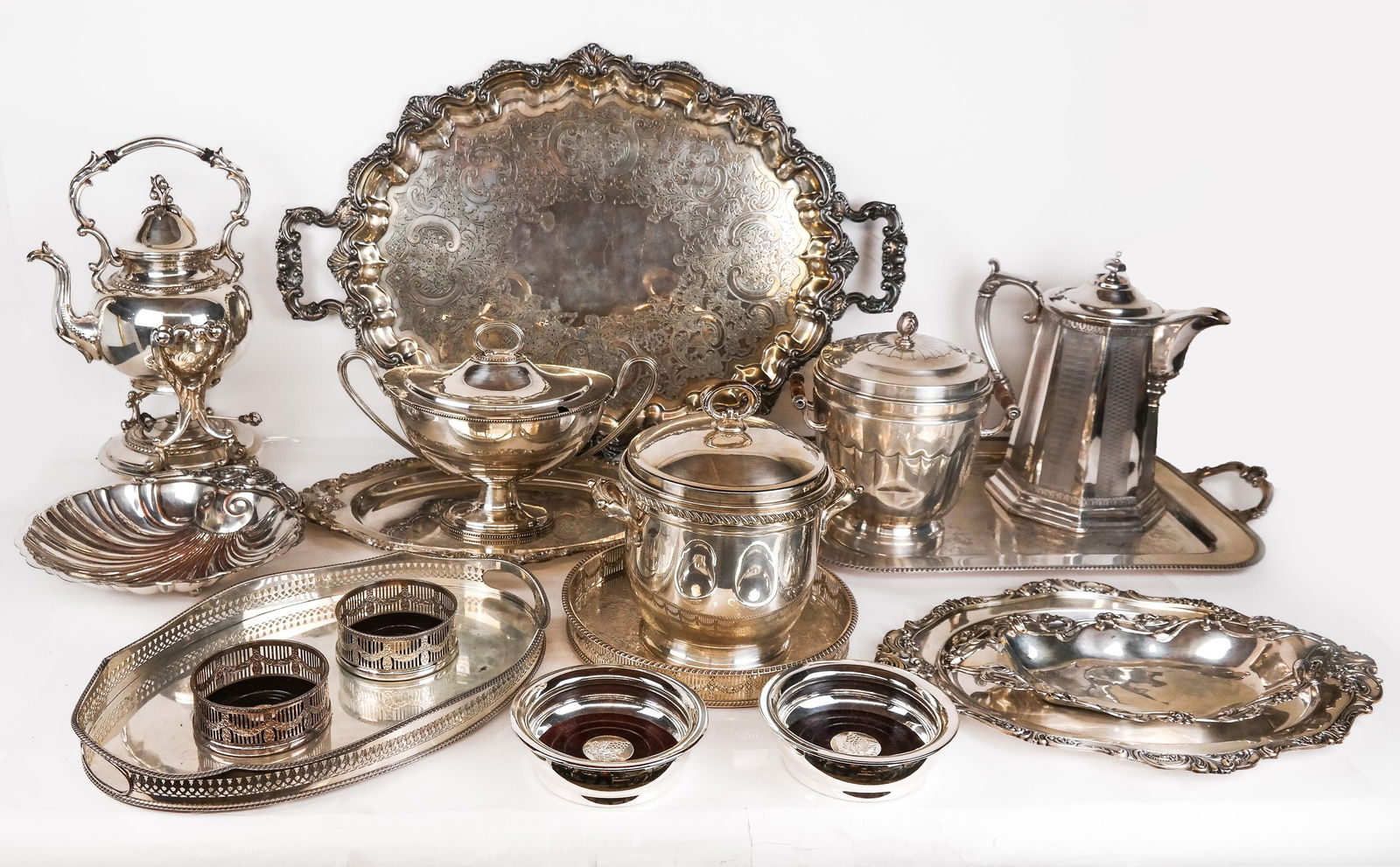 Collection of Silver Plate, 18: Collection of silver plate, comprising Reed & Barton "Double Walled Pitcher" tankard, 2 ice buckets with lids, a double handled tureen, a pair of Wallace "Baroque" pattern oval trays, 2 pair of wine c