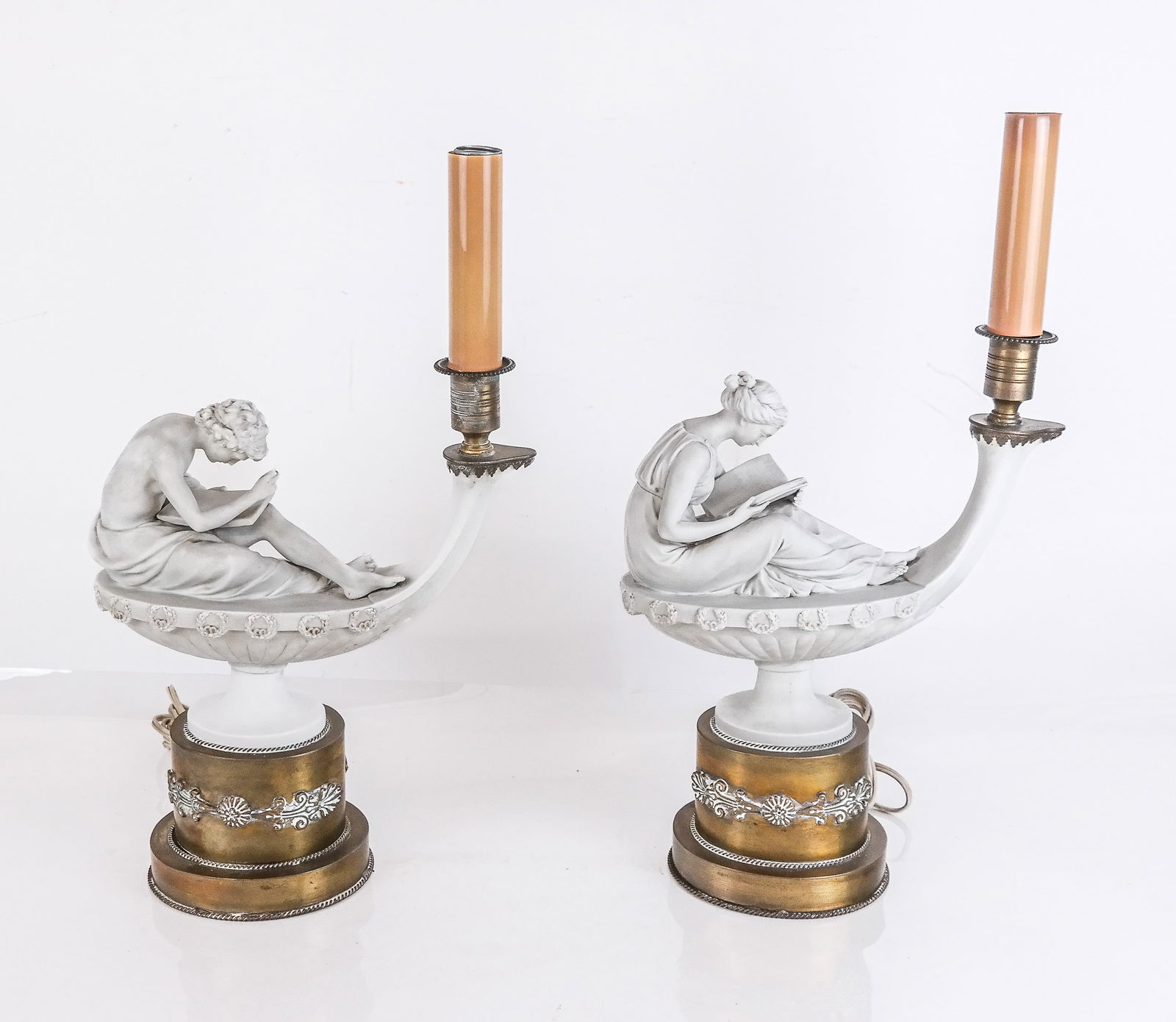 Companion Pair French Neoclassical Figural Lamps,2: Companion pair of French Neoclassical bisque and gilt metal figural table lamps, each figure (male and female) seated, and engaged in reading. [18" H x 10.5" W x 5" D]. Overall condition is good, with