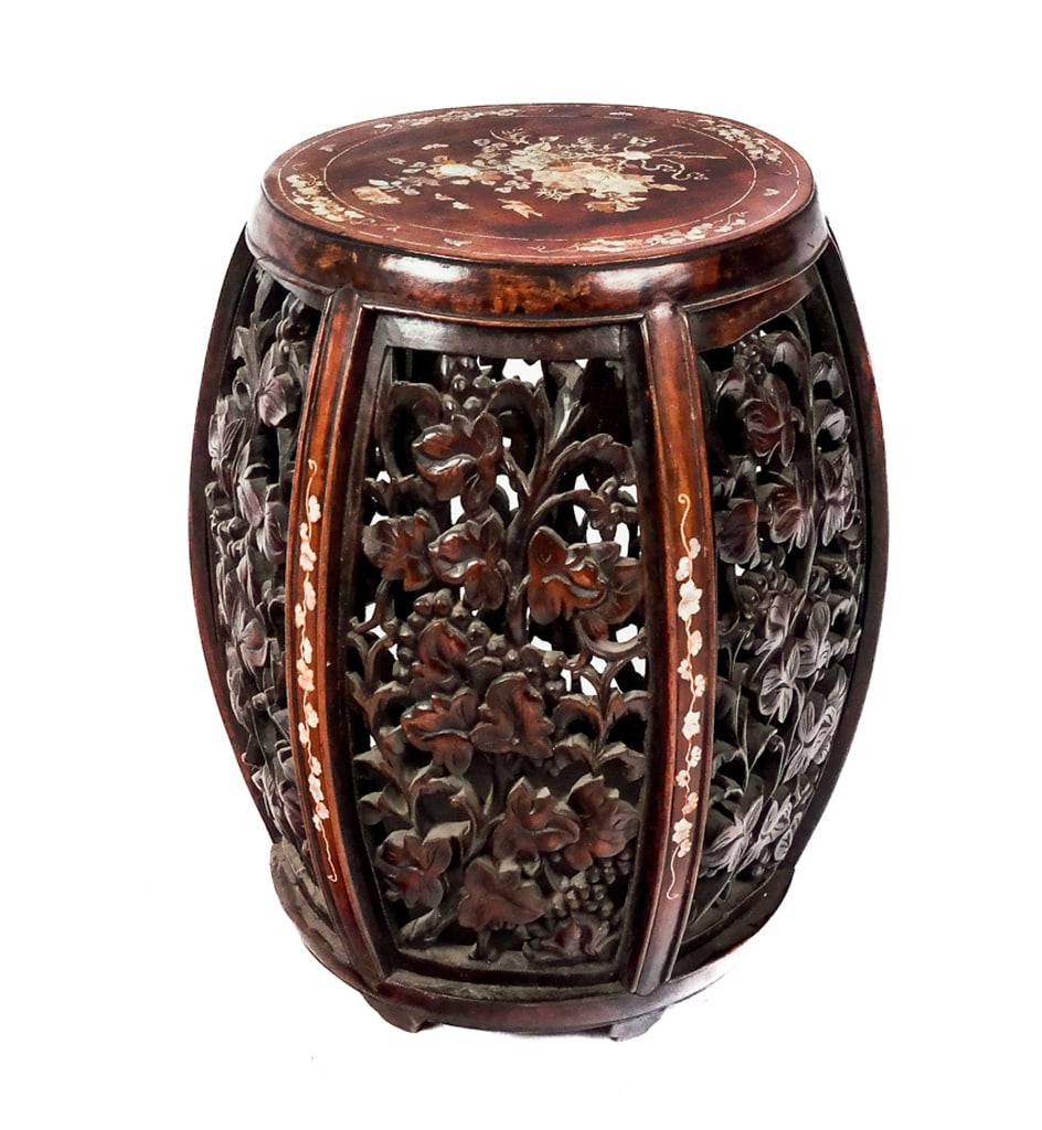 Chinese Rosewood and Mother of Pearl Garden Seat: Chinese carved rosewood garden seat or tabouret, 19th century, with heavily carved floral decoration and mother of pearl inlay. [20" H x 16" Diam.]. Condition is good to fair with minor scattered loss