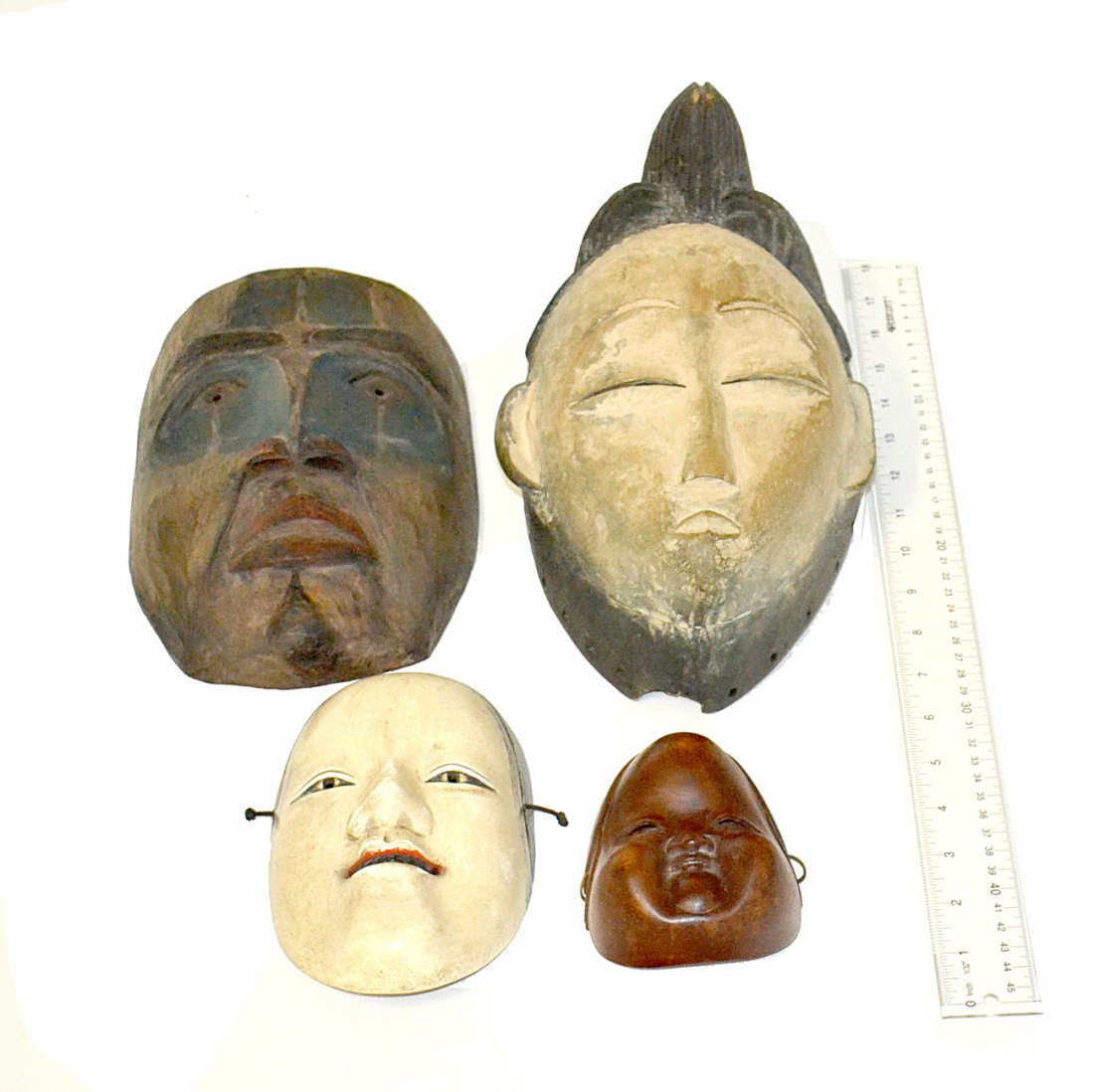 Group of Four Masks: Comprises one mask inscribed with a mark and three Asian style masks, one ceramic. [Largest: 12"H]