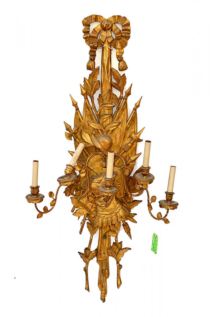 Carved and Gilt Wood Armorial Sconce: Features five arms with gilt tole leafy accents and elaborate back-plate with trophies of war motif. As is, needs restoration. Missing parts of carving near bottom. [23 1/2" W x 7 1/2" D x 48" H]