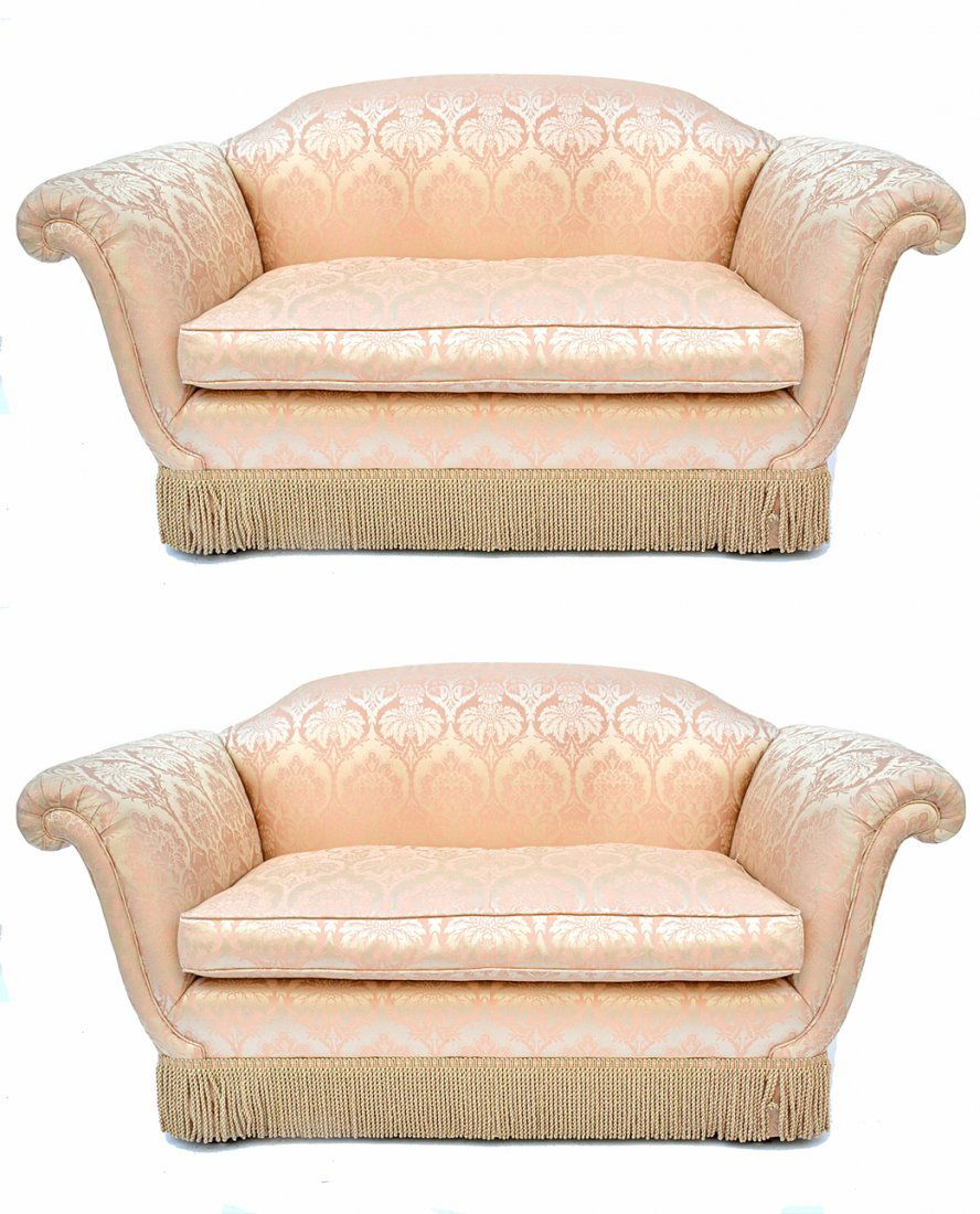 Pair of Scalamandre Damask Upholstered Settees: Salmon damask with floral arabesque pattern and tassel trim. Bears splayed outward rolled arms. Both in good condition. [62" W x 29 1/2" D x 30 1/2" H; 17" H to seat].