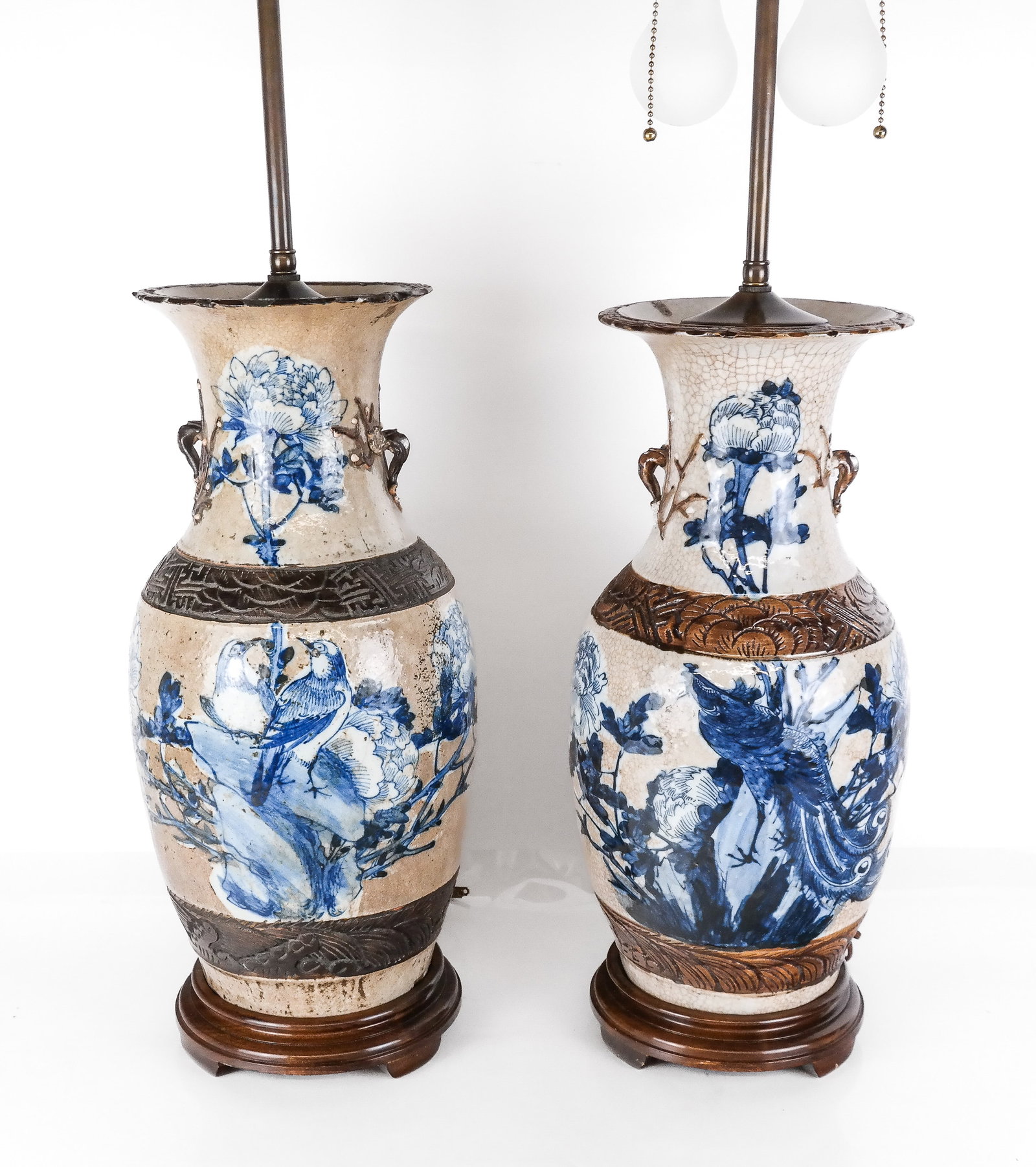 Chinese Pair Qing Dynasty Vases as Lamps: Pair of Qing Dynasty vases, 19th century, with blue and white foliate and bird decoration, and impressed design, later mounted as two-light lamps with a wooden base. [To lip of vase: 19" H x 9" Diamet