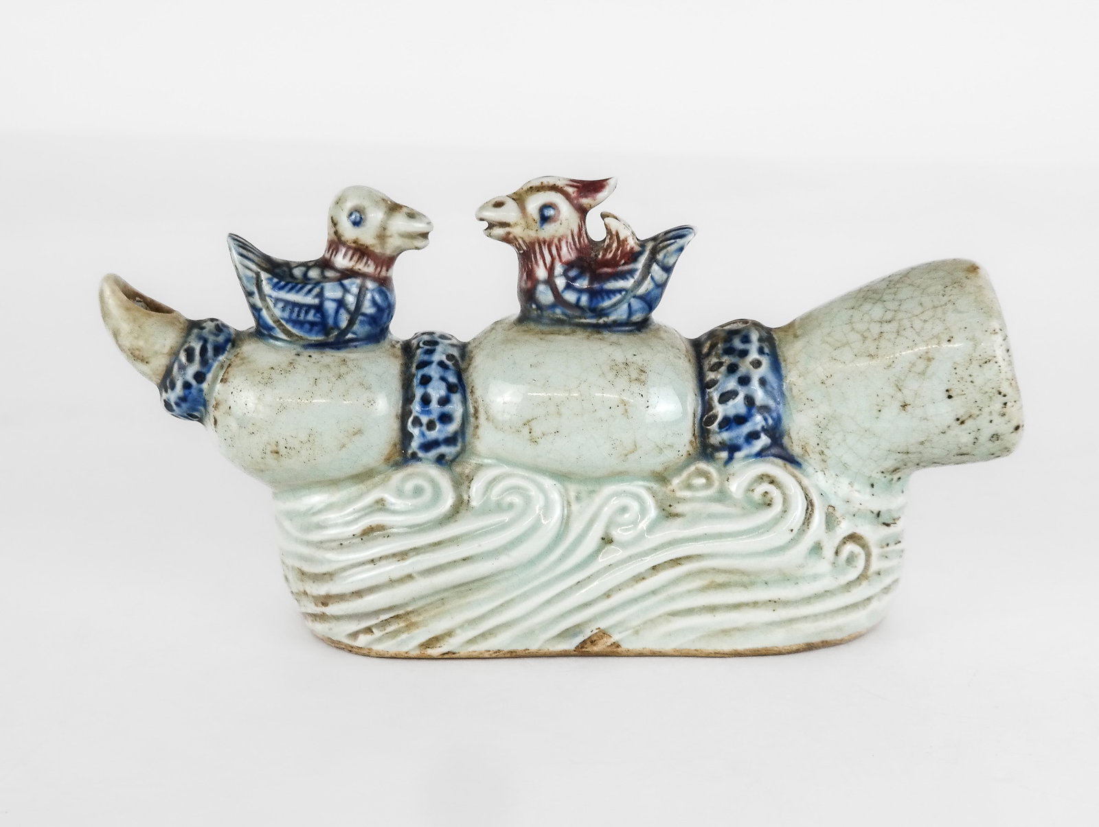 Chinese Qing Dynasty Celadon Sculpture: Chinese Qing Dynasty celadon sculpture, with Guangxu period marks, 19th century, depicting two birds atop a lotus root with wave detail at lower. [5" H x 8.75" W x 2.75" D]. Condition is good with cra